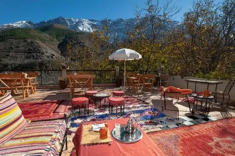 A vibrant patio featuring a colorful rug and umbrella, offering a scenic view of the majestic mountains in the background.