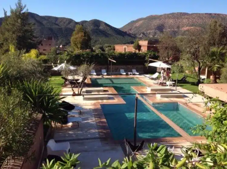 A picturesque pool and lounge area surrounded by stunning mountains, creating a perfect retreat for leisure and relaxation. 