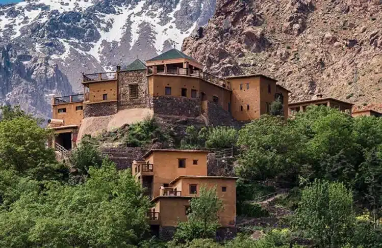  Scenic view of a building in the mountains with a majestic mountain backdrop.