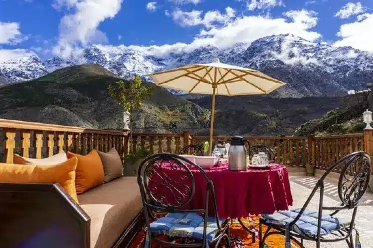 Outdoor patio with table and chairs, scenic mountain view.